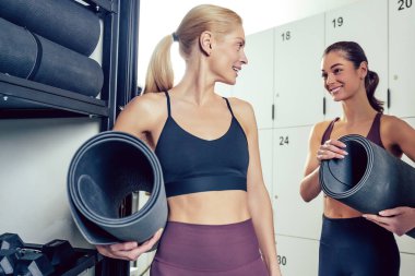 Antrenmandan önce. Spor salonunda paspaslı, taş gibi genç kadınlar.