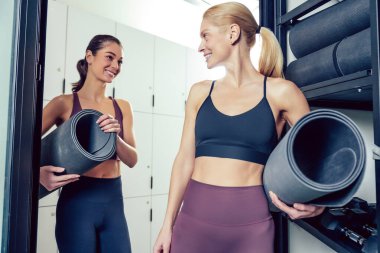 Antrenmandan önce. Spor salonunda paspaslı, taş gibi genç kadınlar.