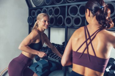 Aktif boş zaman. İki beyaz kadın spor salonunda birlikte vakit geçiriyorlar.