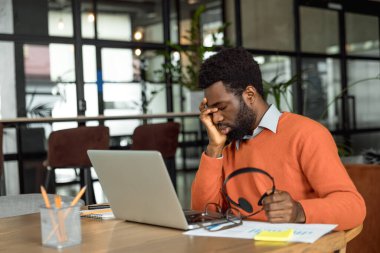 Fazla mesai. Afrikalı Amerikalı girişimci mesai saatlerinden sonra yorgun görünüyor