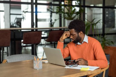 Fazla mesai. Afrikalı Amerikalı girişimci mesai saatlerinden sonra yorgun görünüyor