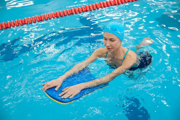 Yüzmenin tadını çıkarıyorum. Mavi şapkalı gülümseyen kadın yüzerken eğleniyordu.