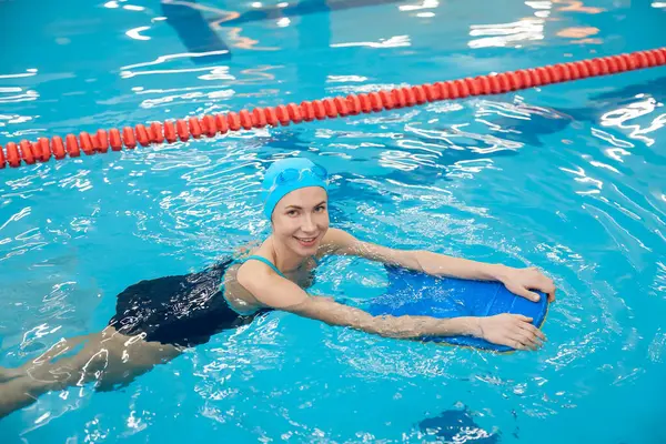 Yüzmenin tadını çıkarıyorum. Mavi şapkalı gülümseyen kadın yüzerken eğleniyordu.