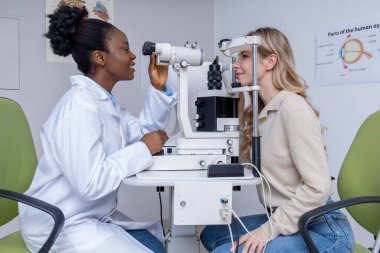 Optometri. Optometriste vizyon muayenesi olan genç bir kadın.