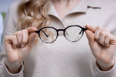 Yeni gözlük. Sarışın bir kadının yeni gözlük taktığı yakın plan.