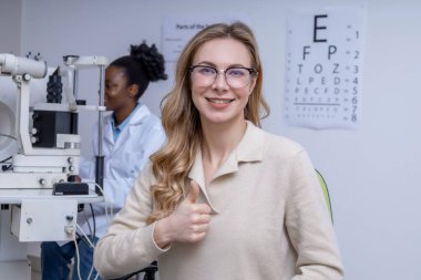 Görme kontrolünden sonra. Optometrist ofisinde yeni gözlüklü sarışın güzel bir kadın.