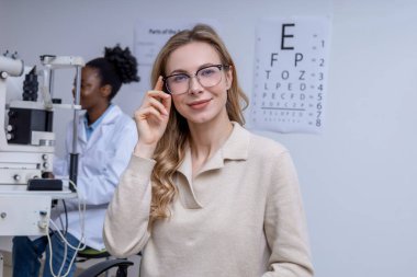 Görme kontrolünden sonra. Optometrist ofisinde yeni gözlüklü sarışın güzel bir kadın.