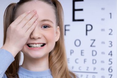 Vizyon testi. Kafkasyalı bir kızın Snellen görüş testi yaptırdığı yakın plan.