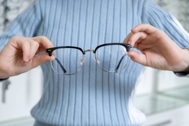 Gözlük. Gözlüklü ellerin resmini kapat