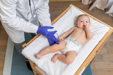 Aşılama. Doktor, küçük tatlı bir çocuğa aşı yapıyor.