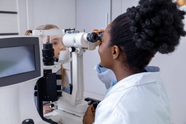 İşteki doktor. Ofisinde çalışan Afro-Amerikan kadın göz doktoru.