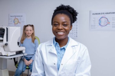 İşteki doktor. Ofisinde çalışan Afro-Amerikan kadın göz doktoru.