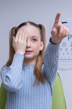 Vizyon sınavı. Kafkasyalı okul çağındaki kız göz doktorunun muayenesinden geçiyor.