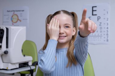 Vizyon sınavı. Kafkasyalı okul çağındaki kız göz doktorunun muayenesinden geçiyor.