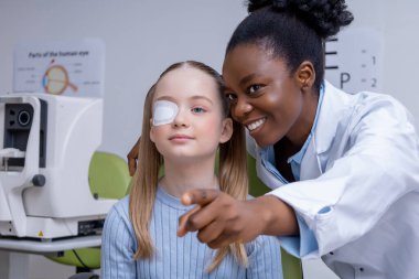 Vizyon sınavı. Kafkasyalı okul çağındaki kız göz doktorunun muayenesinden geçiyor.