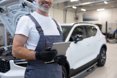 Tamirci atölyede tablet tutuyor