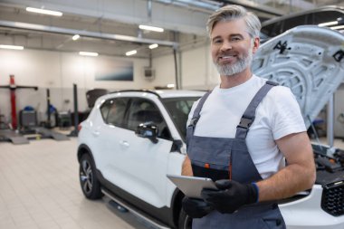 Tamirci atölyede tablet tutuyor