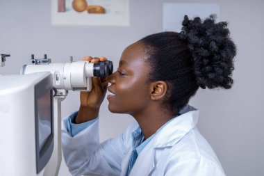 Optik ekipman. Hasta ile çalışırken optik tıbbi araç kullanan kadın göz doktoru