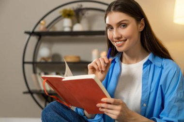 Evdeki kanepede günlük tutan bir kadın. Güzel esmer, evde dinleniyor. Huzurlu vakit geçiriyor.