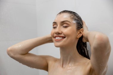 Kahverengi saçlı kadın banyoda jöle ile banyo yapıyor saçlarını yıkıyor evde dinleniyor ve temiz sağlık zamanının tadını çıkarıyor.