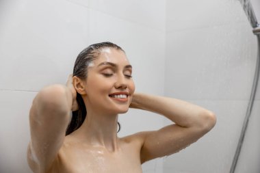 Kadın banyoda suyla duş alıyor cesedi yıkıyor evde dinleniyor sağlıklı cilt bakımının keyfini çıkarıyor.