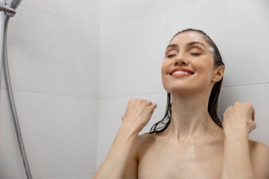 Kahverengi saçlı kadın banyoda jöle ile banyo yapıyor saçlarını yıkıyor evde dinleniyor ve temiz sağlık zamanının tadını çıkarıyor.