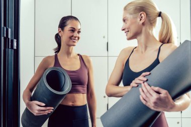 Jimnastik zamanı. Spor salonunda iki genç kadın heyecanlı görünüyor.