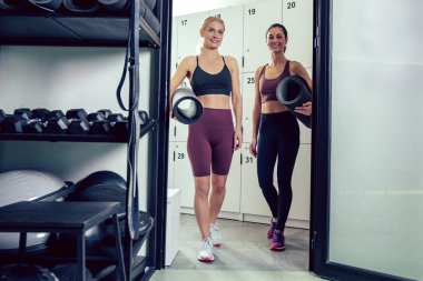 Jimnastik zamanı. Spor salonunda iki genç kadın heyecanlı görünüyor.