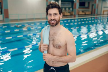 Havuzdaki adam. Yüzme havuzundaki koyu saçlı beyaz adam kendinden emin görünüyor.