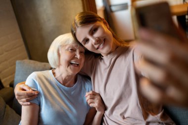 İyi vakit geçiriyorum. Genç bayan gönüllü ve yaşlı kadın selfie çekiyorlar ve eğleniyorlar.