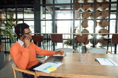 Müşteriyle görüntülü görüşme. Koyu tenli iş adamı internetten arıyor ve işin içinde gibi görünüyor.