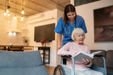Bakım evi. Yaşlı hastasıyla ilgilenen yardımcım okumayı ve mutlu görünmeyi seviyor.