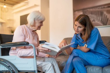 Bakım evi. Yaşlı hastasıyla ilgilenen yardımcım okumayı ve mutlu görünmeyi seviyor.