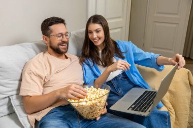 Neşeli aile hafta sonunu evde patlamış mısır yiyerek ve online komedi filmi izleyerek geçiriyor.