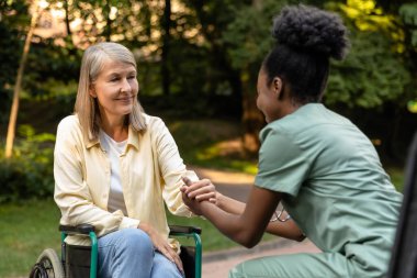 Masaj. Hemşire, kadın bir hastaya masaj topuyla el egzersizi yapmasına yardım ediyor.