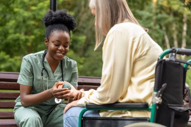 Masaj. Hemşire, kadın bir hastaya masaj topuyla el egzersizi yapmasına yardım ediyor.