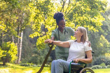 Rehabilitasyon. Parkta bir hastayla çalışan hemşire ve rehabilitasyon egzersizi yapmasına yardım ediyor.