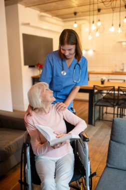 Bakım evi. Yaşlı hastasıyla ilgilenen yardımcım okumayı ve mutlu görünmeyi seviyor.