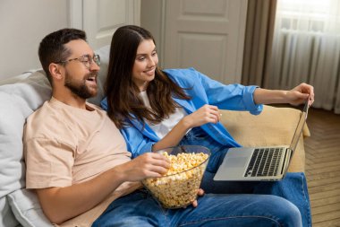 Neşeli aile hafta sonunu evde patlamış mısır yiyerek ve online komedi filmi izleyerek geçiriyor.