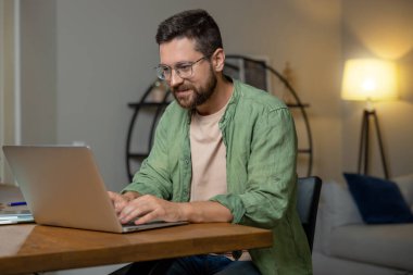 Sakallı adam merkez ofisteki bilgisayardaki verileri kontrol ediyor.