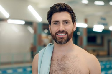 Havuzdaki adam. Yüzme havuzundaki koyu saçlı beyaz adam kendinden emin görünüyor.