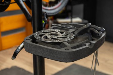 Arka planda aletler bulunan bir atölyedeki tamir tezgahında duran bisiklet tekerleğinin yakın görüntüsü