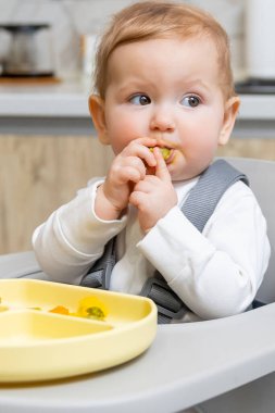 Yavrum. Sandalyesinde otururken yana bakan küçük bir çocuğun portresi.