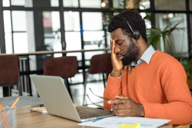 Fazla mesai. Afrikalı Amerikalı girişimci mesai saatlerinden sonra yorgun görünüyor