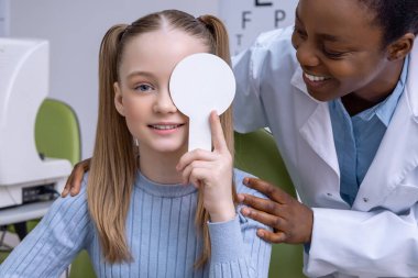 Optometri. Optometrist ofisinde göz testi yaptıran beyaz saçlı bir çocuk.