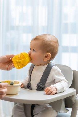 Kahvaltıda. Küçük tatlı oğlan içiciden içiyor.