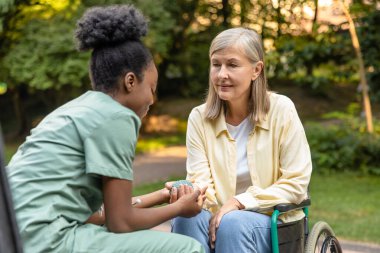 Rehabilitasyon. Parkta bir hastayla çalışan hemşire ve rehabilitasyon egzersizi yapmasına yardım ediyor.