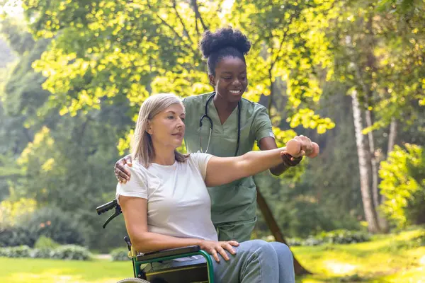 Rehabilitasyon. Parkta bir hastayla çalışan hemşire ve rehabilitasyon egzersizi yapmasına yardım ediyor.
