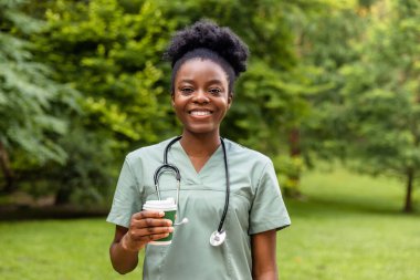 Kahve molası. Afro-Amerikan kahvesini parkta içerken gülümsüyor.