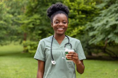 Kahve molası. Afro-Amerikan kahvesini parkta içerken gülümsüyor.